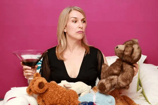 Anne Marie with a martini among teddy bears on a pink set